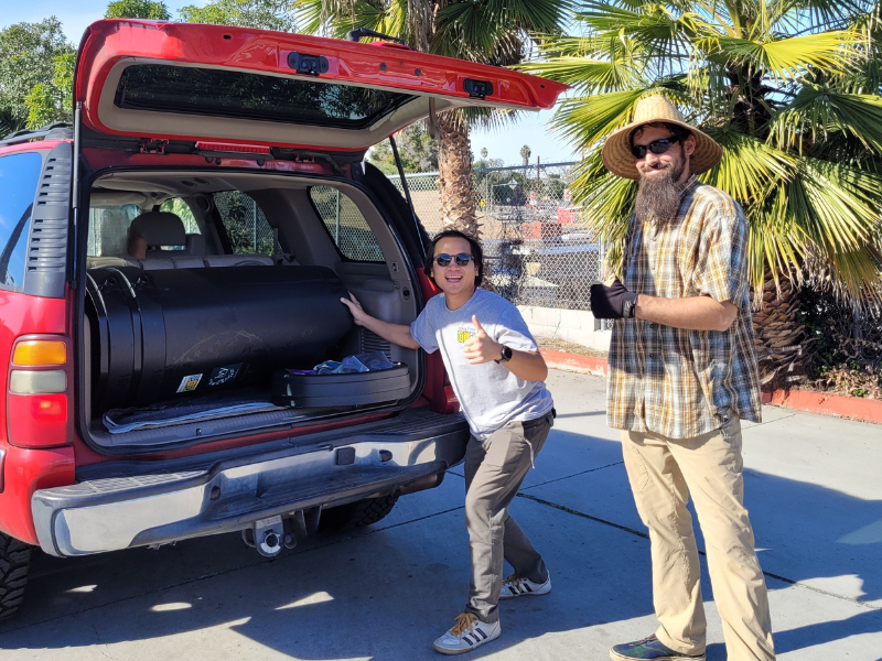 Couple putting a rain barrel in their car