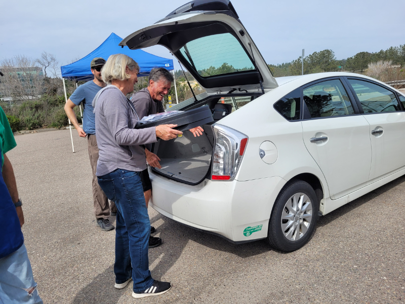 A couple adding water saving materials into their car